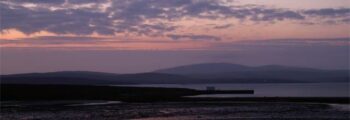 Château au bord de la rivière reflété sur l'eau calme la nuit.